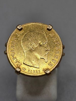 a close up of a gold coin on a white stand