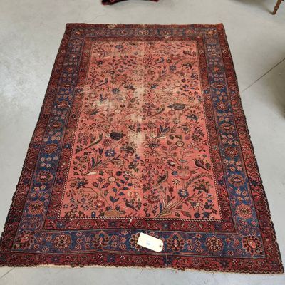 Un tapis persan ancien est posé sur le sol d'une pièce.