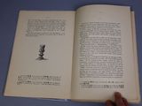 a person holding a book open on a table