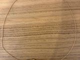 a gold plated necklace with three leaves on a wooden surface