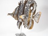 une sculpture métallique représentant un poisson, posée sur un socle