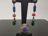 a close up of a pair of earrings on a stand