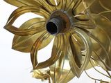 a gold flower on the wall next to a glass vase