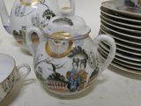 many plates and cups and a teapot on the table