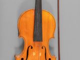 an old violin with a bow and a bow rest on a gray surface
