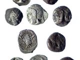 a close up of a group of ancient coins on a white surface