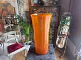 a large orange vase sitting on a table in a living room