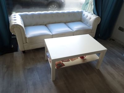 a white couch and a white coffee table in a living room