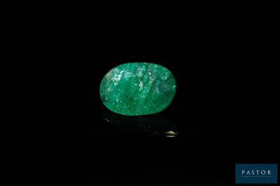 une pierre verte couleur émeraude sur un fond noir