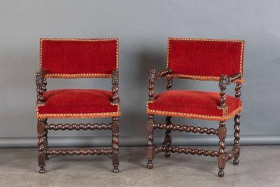 une paire de chaises rouges placées l'une à côté de l'autre sur un sol en béton