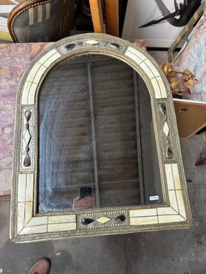 un grand miroir posé sur une table à côté d'une chaise