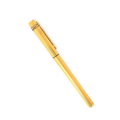 a gold pen sitting on top of a white surface