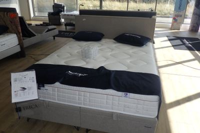 un lit situé dans une chambre dotée de nombreuses fenêtres