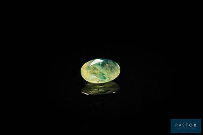 un gros plan d'une bille verte et blanche posée sur une surface noire