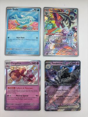 quatre cartes Pokémon différentes posées sur une table avec un fond blanc