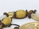 a bracelet with a gold coin and some beads on it