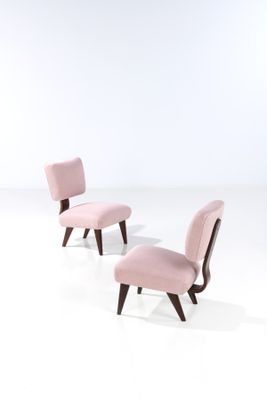 a pair of pink chairs sitting next to each other on a white surface