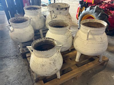 de nombreux pots blancs posés sur une palette dans un garage