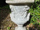 a stone urn sitting in the middle of a forest