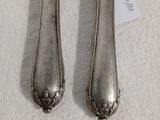 une paire de cuillères plaquées argent posées sur un fond blanc, avec une étiquette de prix