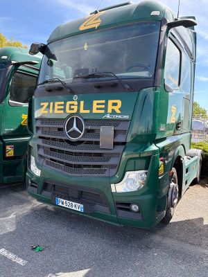 deux camions verts garés l'un à côté de l'autre sur un parking