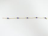 un bracelet en chaîne d'or orné de perles de verre bleues