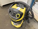 un aspirateur jaune et noir posé par terre