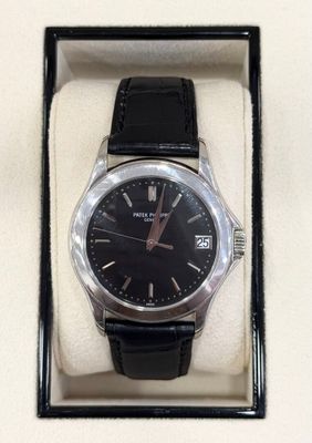 a black watch in a black box on a white surface