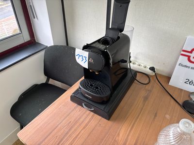 a coffee maker on a table in a small room