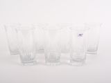 quatre verres transparents sont alignés sur une surface blanche
