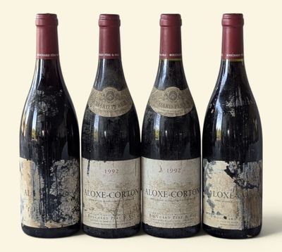 three bottles of red wine are lined up on a table