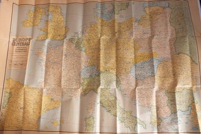 une carte du monde posée sur une table, avec une tasse de café à côté