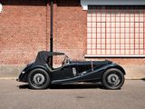 a black vintage car parked in front of a brick building