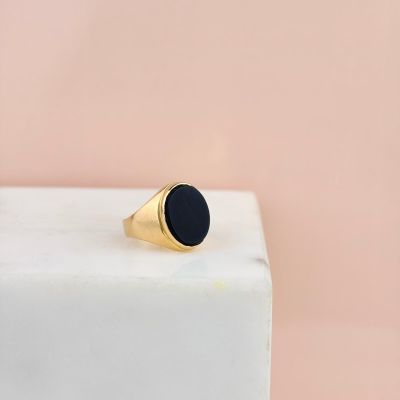 a gold signet ring with a black stone on top