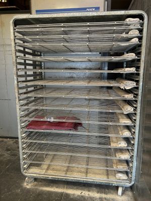 a metal rack with several trays of food on it
