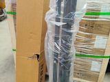 a black umbrella that is wrapped in plastic and sitting on top of a cardboard box