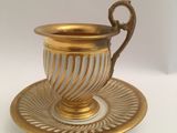 a cup and saucer on a saucer on a white table