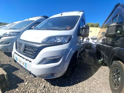 une camionnette blanche garée à côté d'autres voitures