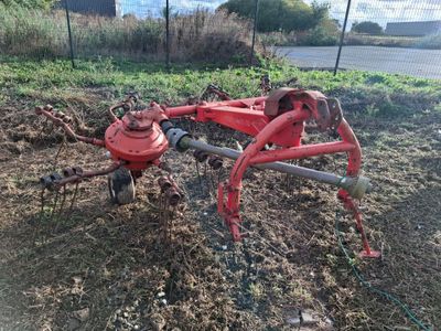 une charrue rouge posée dans la terre