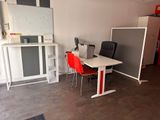 a room with a table, chairs, and a refrigerator