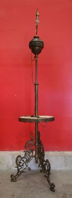 une table sur laquelle est posée une lampe, devant un mur rouge