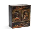une armoire peinte en noir et or, dotée de deux portes et de tiroirs