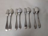 five forks and five spoons on a table