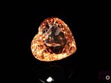 un gros plan d'un diamant posé sur une surface noire, avec un fond noir