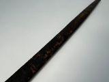 a very long knife that is on a white table
