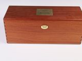 an old wooden box with a brass plate on top of it
