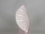a pink vase that has a leaf on it