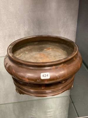 un saladier en métal portant un numéro, posé sur une table en verre