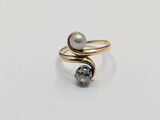 a close up of a ring with a pearl and a diamond