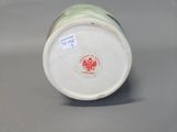 a white and green vase with a red eagle on it